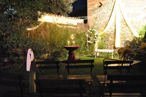 Espai de la cerimònia de nit, amb cadires, flors i l'arc il·luminat al fons