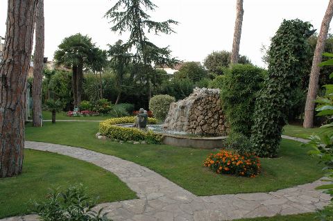 Camino de piedra por el jardín hacia la fuente con cascada