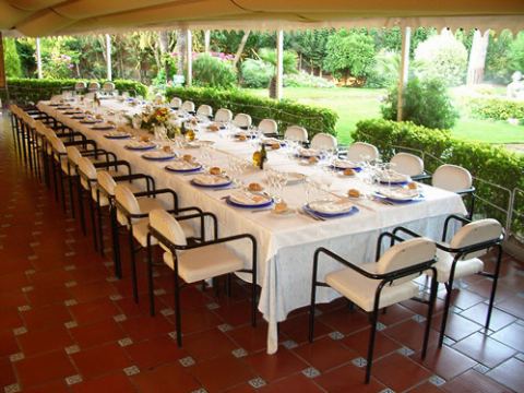 Mesa larga puesta bajo el toldo, con vista al jardín