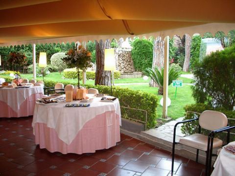 Mesas puestas en el porche con una vista abierta al jardín