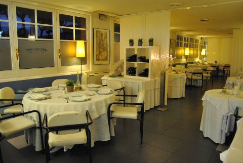 Sala amb finestrals, prestatge de vins i taules parades