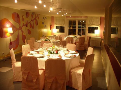 Sala amb paret decorada, taula rodona parada i centre floral