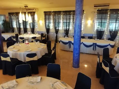 Vista de la sala con la columna azul y las mesas puestas