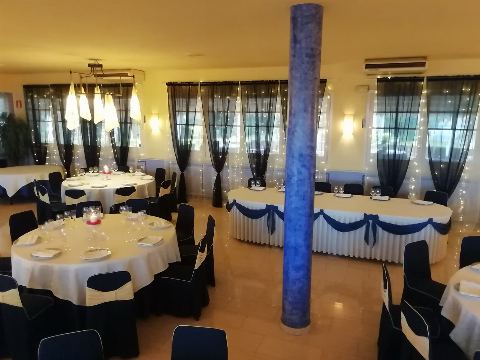Mesa presidencial con lazo azul y mesas redondas puestas